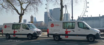 Deux véhicules de Lbox communications garés devant le London Eye