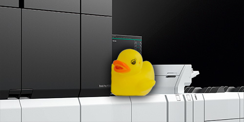 A yellow plastic duck placed on a Fujifilm Revoria Press PC1120