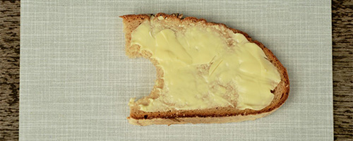 A piece of bread with a thick layer of butter